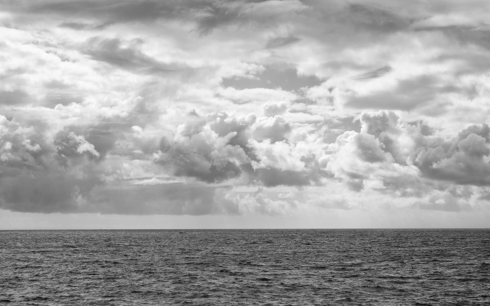 A grey sea and a low squall line across the horizon