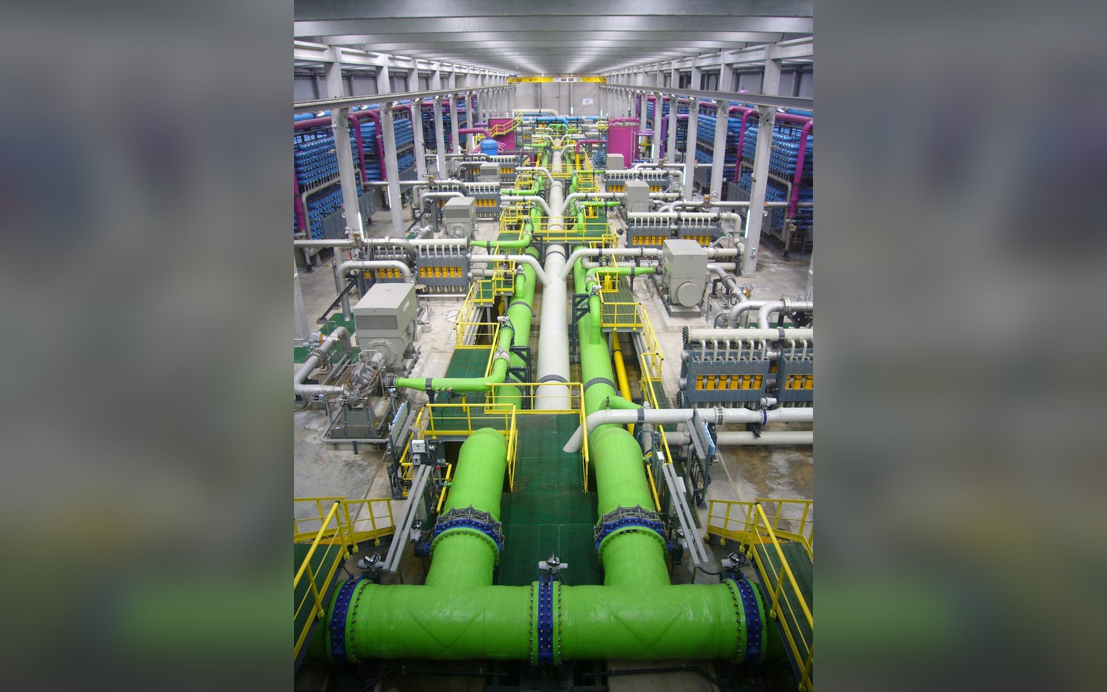Rows of green pipes and membrane filtration units inside a reverse osmosis desalination plant